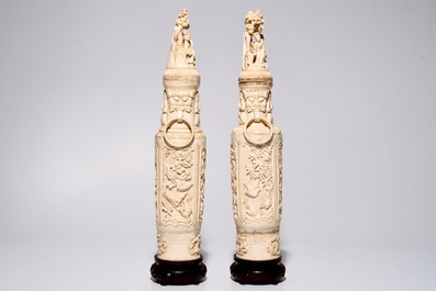 A pair of tall Chinese ivory vases and covers on wooden base, early 20th C.